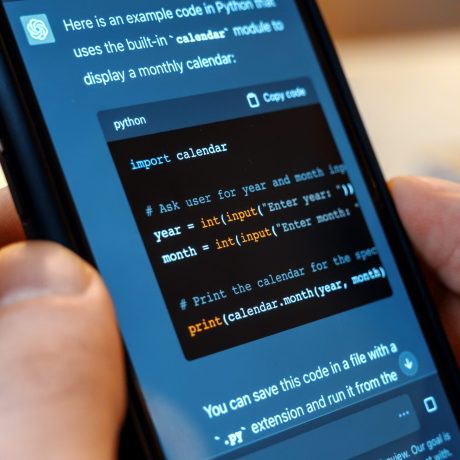 Smartphone with opened AI chat in it Person holding a smartphone with opened AI chat in it. User asking chat bot to write code in Python
